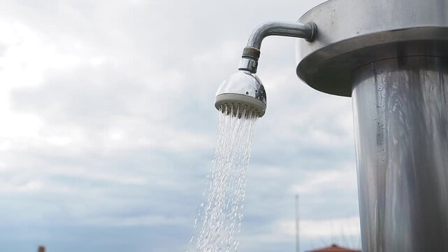 Outdoor shower flows water under cloudy sky