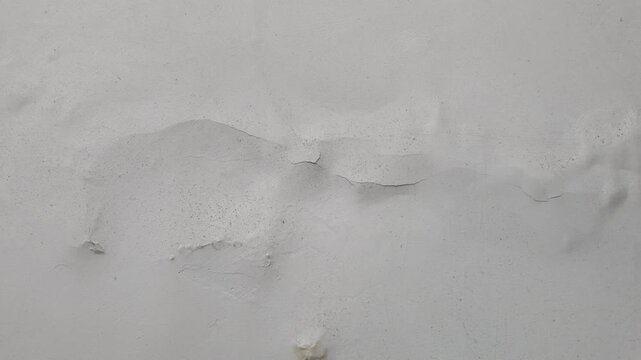 Video of large sections of paint peeling away from the wall, revealing the substrate underneath. Representative of poor adhesion or dampness.