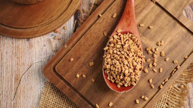 Cooking with fenugreek seeds in a wooden spoon