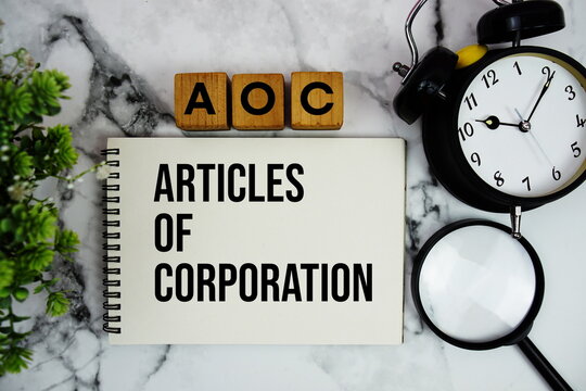 AOC Articles of Corporation text with alarm clock and magnifying glass on marble background
