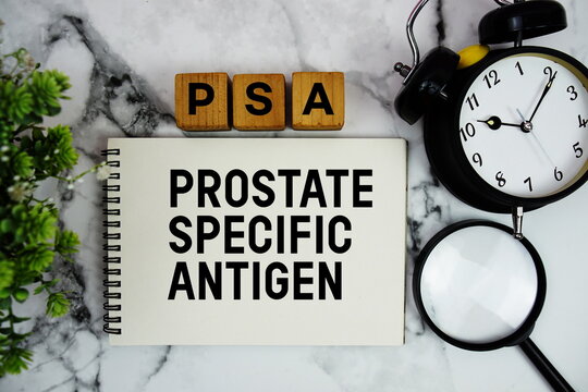 PSA Prostate Specific Antigen text with alarm clock and magnifying glass on marble background