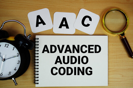 AAC Advanced Audio Coding text written on notepad with magnifying glass and alarm clock on wooden background