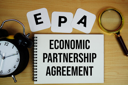 EPA Economic Partnership Agreement text written on notepad with magnifying glass and alarm clock on wooden background