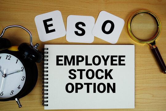 ESO Employee Stock Option text written on notepad with magnifying glass and alarm clock on wooden background