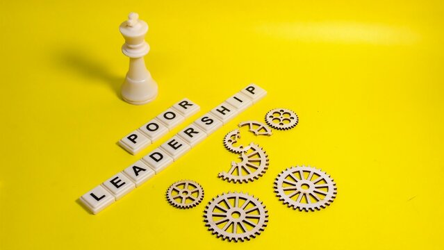 A white chess king stands above "POOR LEADERSHIP" tiles and broken wooden gears on a yellow background, symbolizing the mechanical failure and strategic breakdown caused by ineffective management.