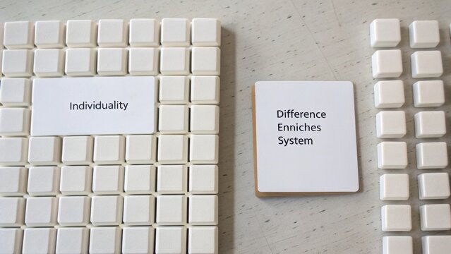Conceptual representation of individuality and system differences using white blocks and cards on a neutral background for creative design and visual communication