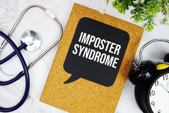 Imposter Syndrome text with stethoscope and alarm clock on marble background