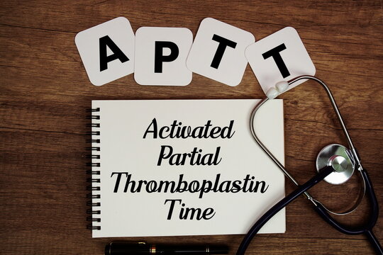 APTT Activated Partial Thromboplastin Time text written on notepad with stethoscope on wooden background