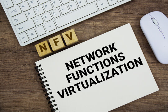 NFV Network Functions Virtualization message with keyboard and optical mouse on wooden background