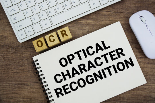 OCR Optical Character Recognition message with keyboard and optical mouse on wooden background