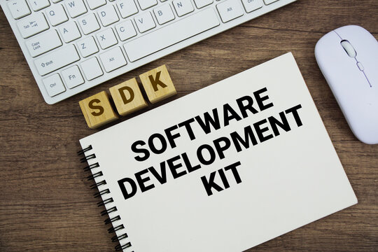 SDK Software Development Kit message with keyboard and optical mouse on wooden background