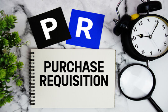 PR Purchase Requisition text written on notepad with alarm clock and magnifying glass on marble background