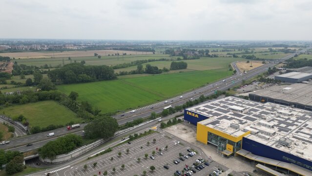 Aerial View of Ikea Retail Center and Highway: An expansive aerial perspective captures a large retail complex with a distinctive yellow and blue facade situated beside a busy highway.
