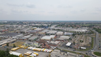 Fototapeta premium Industrial Cityscape: An expansive view showcases the vibrant heart of industry and commerce, featuring an intricate network of warehouses, San Giuliano Milanese, Milan, Italy, 