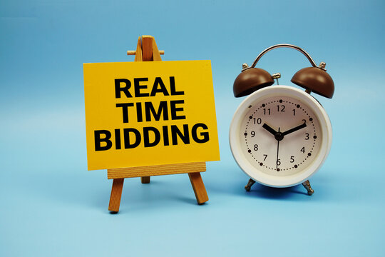 Real Time Bidding text with alarm clock on blue background