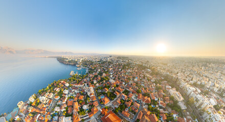 Naklejka premium Antalya, Turkey. Kaleici Old Town, dense terracotta rooftops and historic harbor, aerial panoramic view at sunrise over the Mediterranean coast