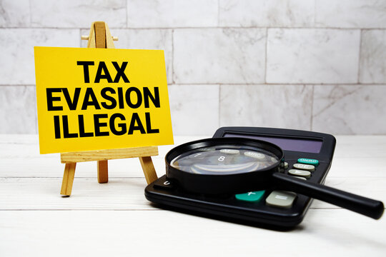 Tax Evasion Illegal text with calculator and magnifying glass
