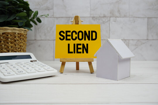 Second Lien text with house model and calculator on wooden background