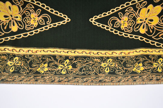 Traditional Indonesian batik fabric with floral motifs and parang pattern. Black, yellow, and brown textile background for fashion and interior design.