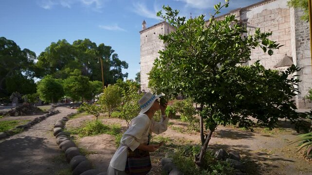 Mature woman enjoys the Mission Church in San Ignacio Baja California while sightseeing and taking in the local plants and scenery