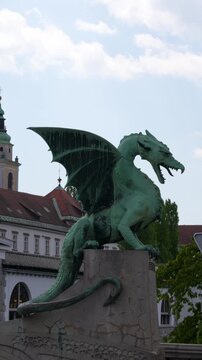 Vertical shot of the iconic green dragon statue on Zmajski Most in Ljubljana. Authentic cinematic travel footage of a famous European landmark.