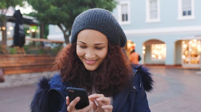 Woman, smile and scroll in city with phone, text message and social media post for winter holiday. Happy, person and typing outdoor in urban town with tech, mobile app and cold weather on vacation.