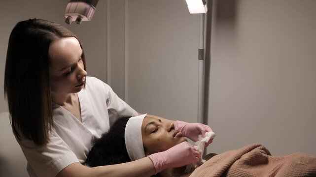 A Black woman receiving a professional facial treatment during Black History Month. Concept of inclusive beauty, self-love, and Juneteenth wellness