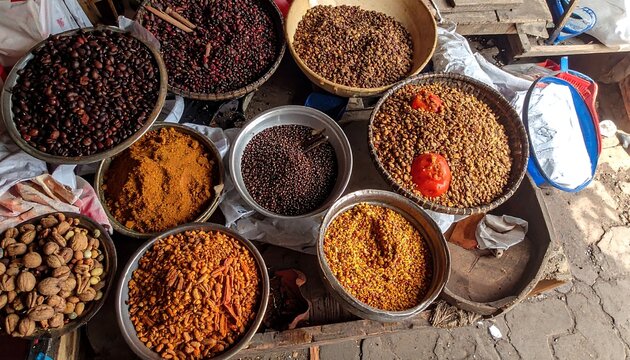 Spices and herbs on display at an outdoor market stall in India.