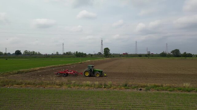 Agricultural Symphony: A tractor cultivates the land, shaping the fertile fields, symbolizing the cyclical relationship between agriculture and nature's bounty.