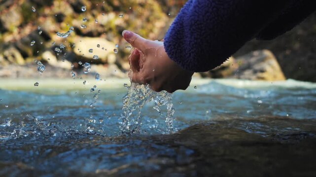 Slow Motion Close-up: Washing Hands in Crystal Clear Mountain River