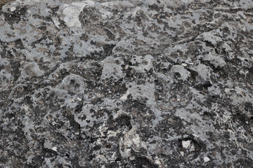 Rough grey stone surface texture with dark weathering spots © k49red