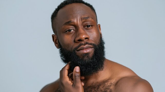 Close-up of a young black man analyzing his stubble and skin texture for a perfect grooming result in his home.