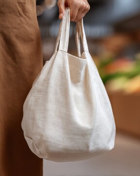 Person using cloth bag instead of plastic bag in store, sstkgreen