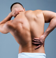 Naklejka premium Neck pain, back and man with sore muscle, health problem or workout strain on gray background. Spine, injury and male with stress or tension with body ache, bad training or exercise inflammation
