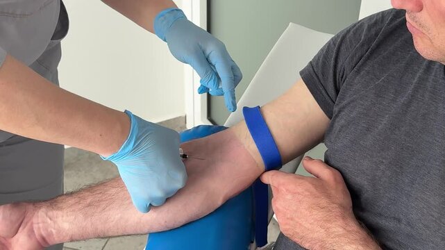 Nurse in blue latex gloves collecting blood sample from patient vein during clinical laboratory testing procedure sterile healthcare practices, routine clinical examination in medical environment. 