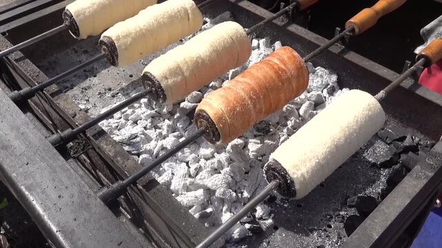 Hungarian chimney cake kurtoskalacs roasting on coals