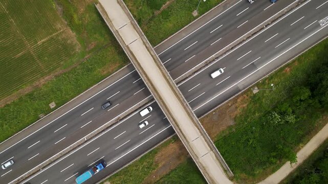 Roadscape Overhead: Aerial view of a modern highway infrastructure with multiple lanes of traffic, integrated with pedestrian overpass. Capturing the urban design and transport system