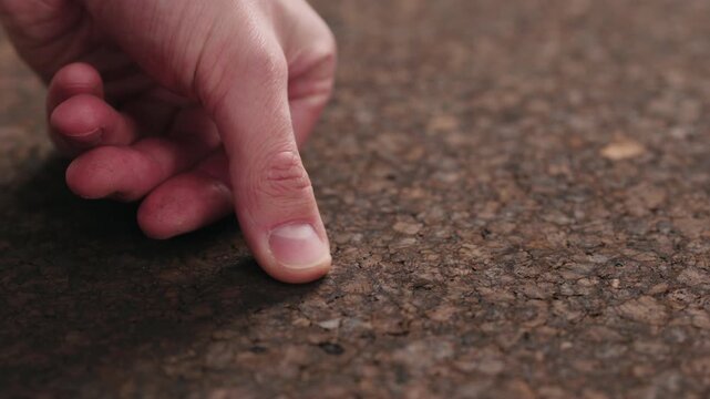 Slow motion man hands touch dark cork surface with oil finish