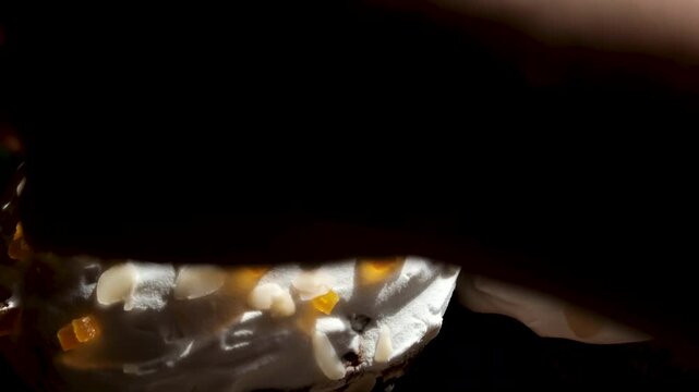 Easter bread topped with white glaze, almond flakes, and dried fruits in a festive bakery-style presentation