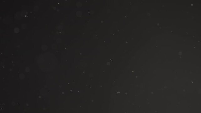 Slow motion real dust particles floating mid air over dark background