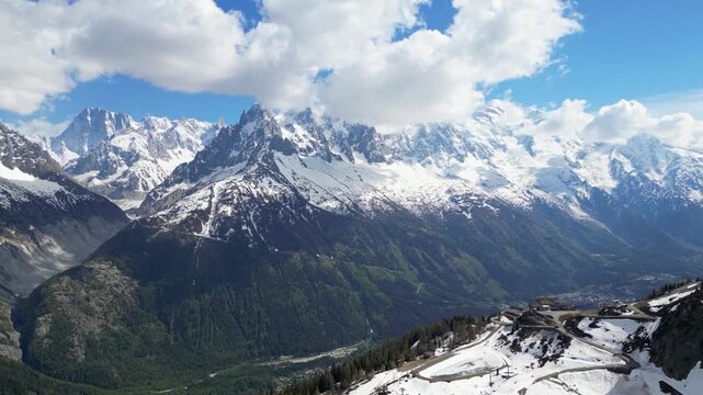Epic aerial drone view of the Mer de Glace glacier flowing through the rugged alpine mountains near Chamonix, France, with towering snowy peaks and dramatic landscapes of the Mont Blanc massif capture