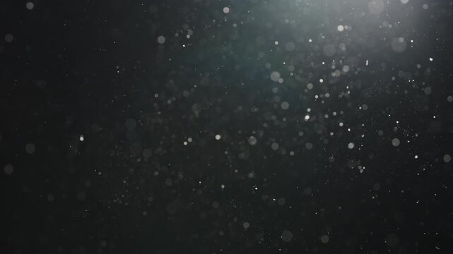 Slow motion real dust particles floating mid air over dark background