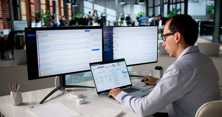 Fototapeta na wymiar Middle-aged Man Uses Laptop Reviewing CAPA Reports
