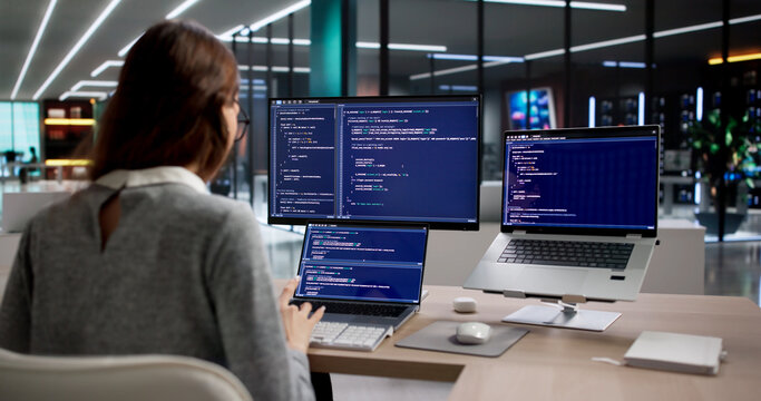 Woman Programmer Types Code Diligently On Desktop