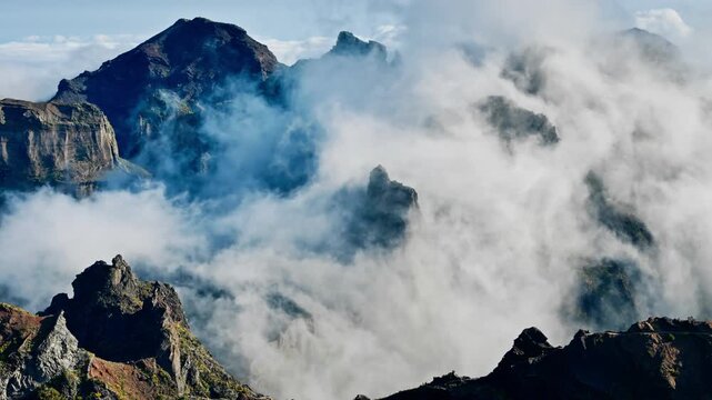 Dynamic cloud movement around mountain peaks near Pico do Arieiro, Madeira, aerial view