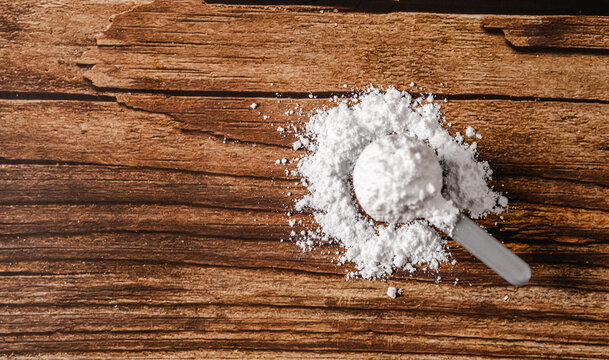 Sports supplements on a wood table background with copy space. Top view composition wiith creatine.