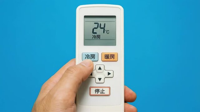 エアコンのリモコン操作で冷房24度に設定する手元のアップ