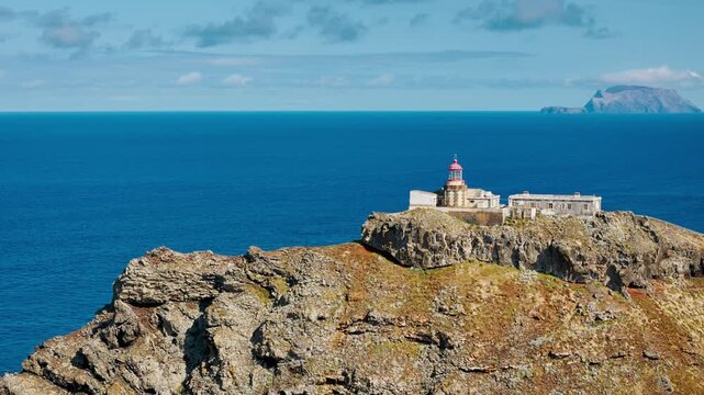 Farol Sao Lourenco lighthouse on rugged coastal dramatic cliffs and open ocean, eastern Madeira from drone