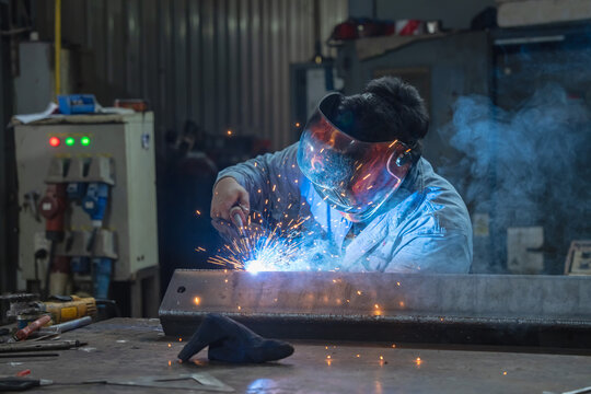 Welding action in industrial workshop welding process factory environment close-up view metal fabrication