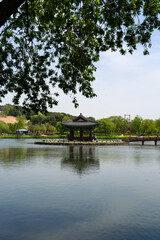 Fototapeta premium Gungnamji Pavilion Framed by Green Leaves in Vertical View